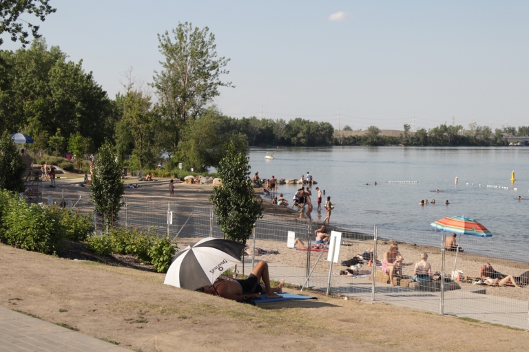 Verdun Beach A sunny beach with some people in the water and other in the sand.